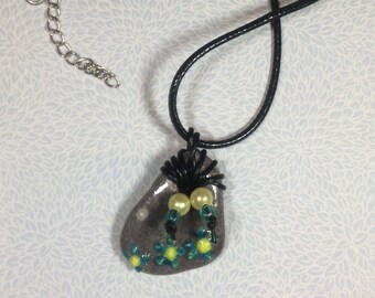 Hand painted sea stone pendant with leather and pearl decoration on a leather thong