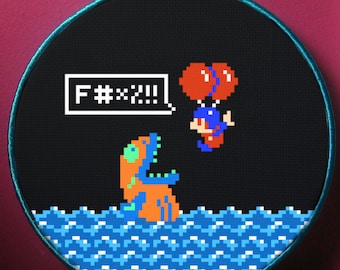 May include: A black and white pixel art cross-stitch embroidery hoop with a blue, orange, and green creature in the water. The creature is saying "F**k!!!" in a speech bubble. A red and blue character is floating above the water with two red balloons.