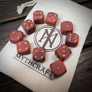 May include: Ten reddish-brown dice with gold dots are displayed around a canvas bag. The bag features a logo and the word "MYTHCRAFT". These dice are a classic gaming accessory, perfect for tabletop games.