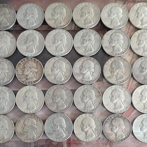 May include: A collection of silver United States quarters, each displaying a profile of George Washington. Some coins show signs of wear and age, with varying levels of detail visible on the surface.