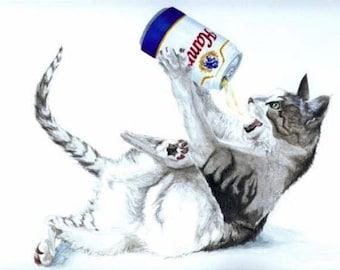 May include: A white and gray cat with black stripes is lying on its back with its paws in the air. The cat is holding a can of beer in its paws and is pouring the beer into its mouth. The can of beer is blue and white with the word "Coors" printed on it.