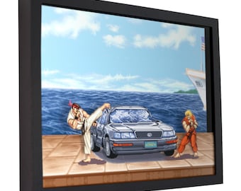 May include: A framed pixel art print of a scene from the video game Street Fighter. The scene depicts Ryu kicking a gray car with a cracked windshield. Ken is standing in the background. The scene is set against a blue ocean and a cloudy sky.