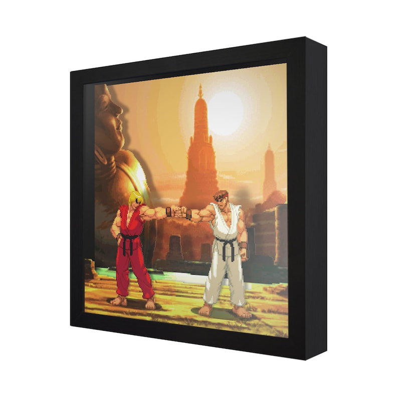 May include: A framed pixel art print of two video game characters, Ryu and Ken, facing each other in a fighting stance. The background is a sunset scene with a large temple in the distance.