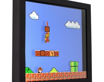 May include: A framed pixel art scene of a video game character, Mario, jumping over a question mark block. The background is a blue sky with white clouds. The scene is set in a classic video game world with green hills and a pipe.