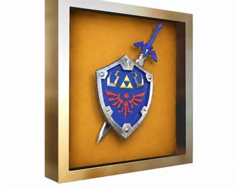 May include: A square gold-toned shadow box frame containing a blue shield with a silver border, a red bird emblem, and a yellow triangle symbol, positioned behind a blue and silver sword with a winged crossguard, set against a mustard yellow background.