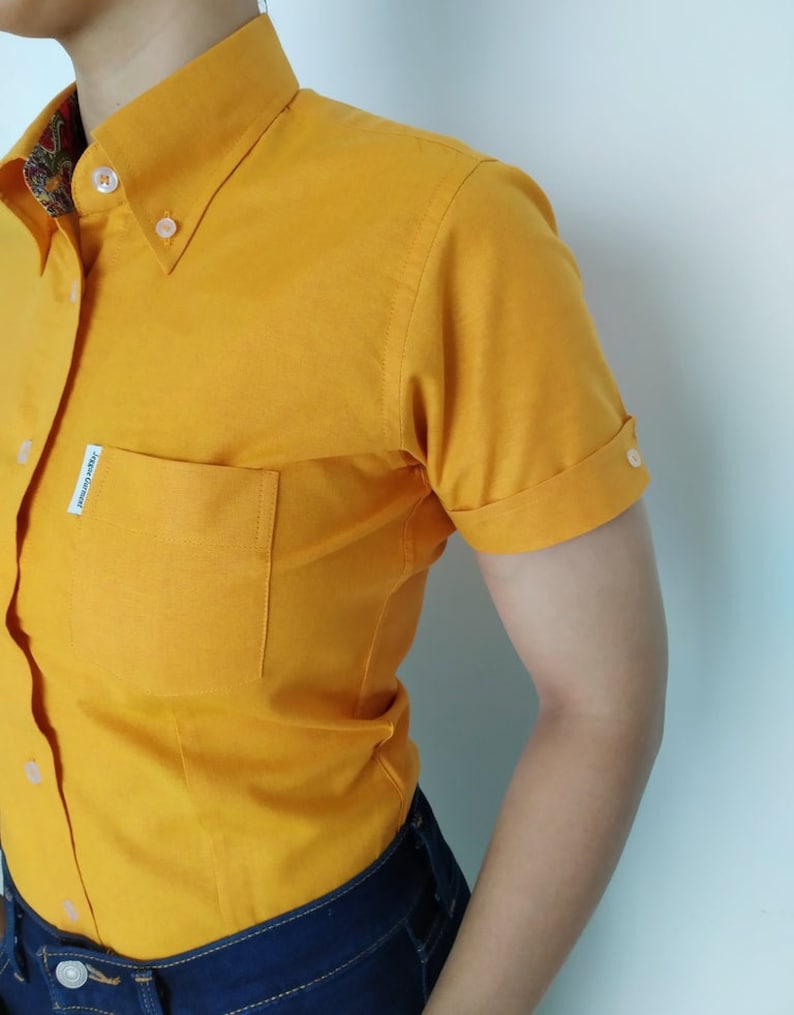 Peut inclure: Une chemise boutonn&eacute;e &agrave; manches courtes de couleur jaune avec une seule poche sur la poitrine gauche. La chemise a un col boutonn&eacute; et une petite &eacute;tiquette sur la poche qui indique "Jack & Jones".