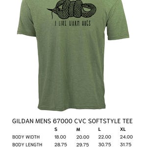 May include: Olive green Gildan t-shirt with a black graphic of a coiled snake and the text "I LIKE WARM HUGS." The shirt is a Gildan Mens 67000 CVC Softstyle Tee. Body width ranges from 18.00 to 24.00 inches.