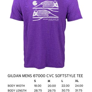 May include: Purple Gildan softstyle tee with a white opossum graphic and text. The shirt has a crew neck and short sleeves. Body width is 45.72 cm (S), 50.8 cm (M), 55.88 cm (L), 60.96 cm (XL). Made by Smiling Snake Shirt Co.