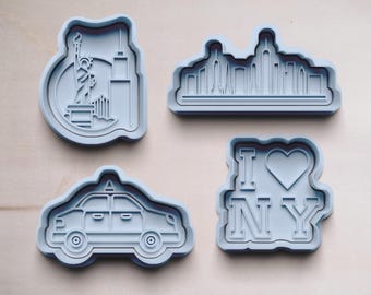 以下が含まれることがあります： ニューヨークのランドマークの形をした灰色のプラスチック製のクッキーカッター4個。カッターは、自由の女神、ニューヨークの街並み、タクシー、そして「I Love NY」の文字の形をしたクッキーを作るためのものです。