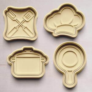 May include: Four cookie cutters in the shape of a chef's hat, a pot, a frying pan, and a fork and spatula crossed.