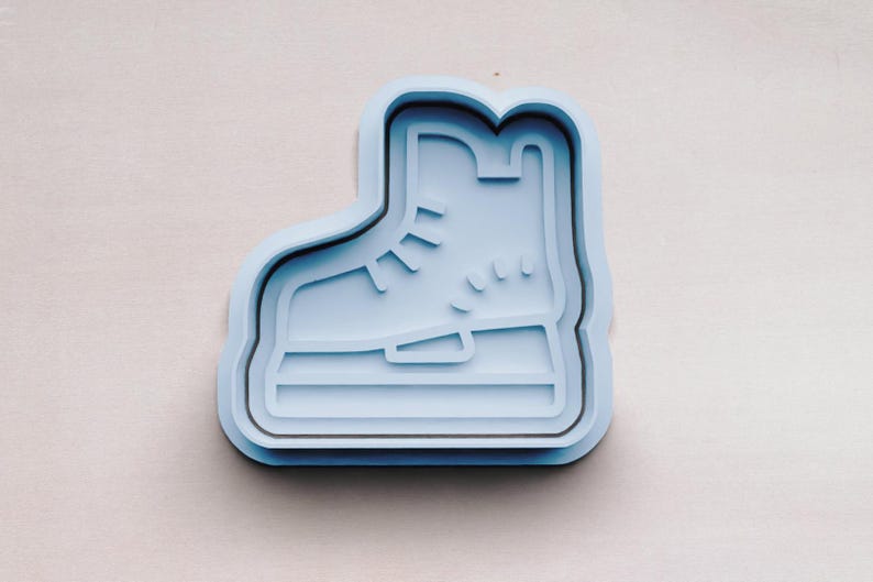 May include: A light blue plastic cookie cutter shaped like an ice skate.
