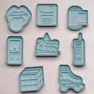 Puede incluir: Nueve cortadores de galletas azules con forma de lengua, disquete, cinta de cassette, consola de juegos, el número 2003, teléfono móvil, cubo de Rubik y patines.