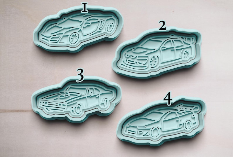 May include: Four different cookie cutters shaped like cars. The cutters are made of light blue plastic and are numbered 1 through 4.