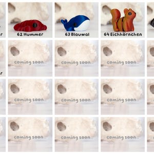 May include: A collection of small animal figurines including a tan platypus, red lobster, blue whale, orange squirrel, black scorpion, and red ladybug. Each item is labeled with a number and name, such as 61 Schnabeltier and 66 Marienk&auml;fer.