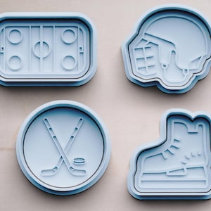 Puede incluir: Cuatro cortadores de galletas de plástico azul con forma de equipo de hockey. Los cortadores son para un disco de hockey, un palo de hockey y un disco, un casco de jugador de hockey y un patín de hockey.
