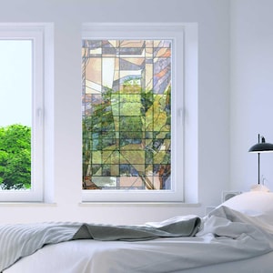 May include: A white window with a stained glass design featuring a geometric pattern of green, brown, and beige shapes. The window is in a white-walled room with a bed and a lamp.