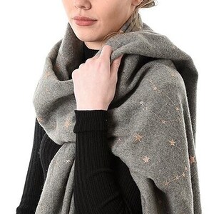 model wearing a grey blanket scarf with an all over gold constellation print