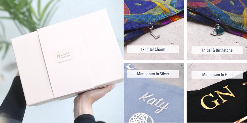 May include: A pink gift box with the text "Aurora Hand Made" on the top. The box is open and shows a variety of personalised gifts, including a scarf with a charm, a scarf with a birthstone, a scarf with a silver monogram, and a scarf with a gold monogram.