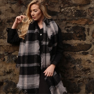 model wearing oversized winter scarf in black and grey tartan