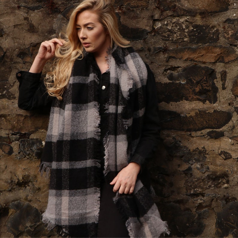 model wearing oversized winter scarf in black and grey tartan