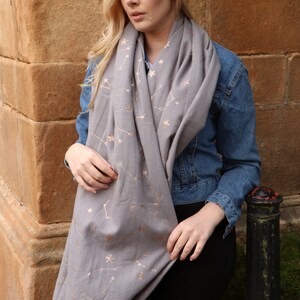 model wearing a warm winter scarf with a constellation and star print