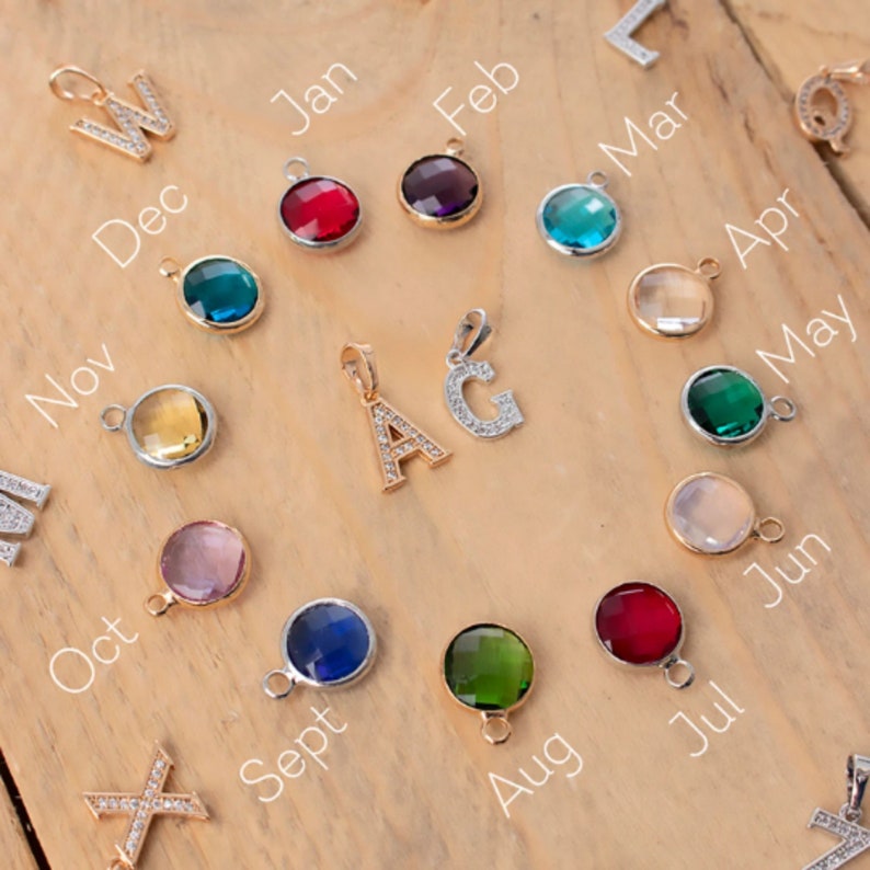 showing the initial and birthstone charms which can be purchased to create a personalised gift