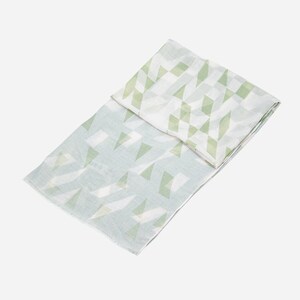 May include: A light green and white patterned scarf with a geometric design. The scarf is made of a soft, lightweight fabric.