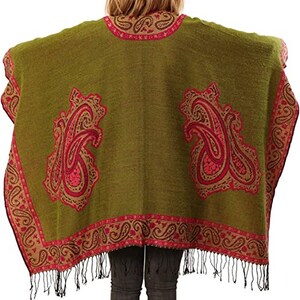 model showing the large pink paisley pattern on the back of the green poncho