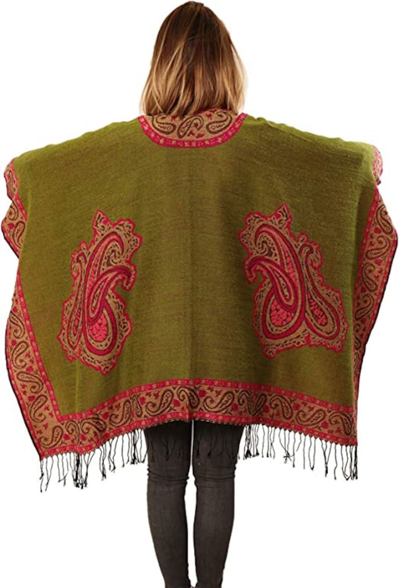 model showing the large pink paisley pattern on the back of the green poncho