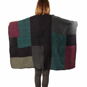 model showing the back of the poncho with all the colours, teal,black, grey, purple and grey in colourblocks
