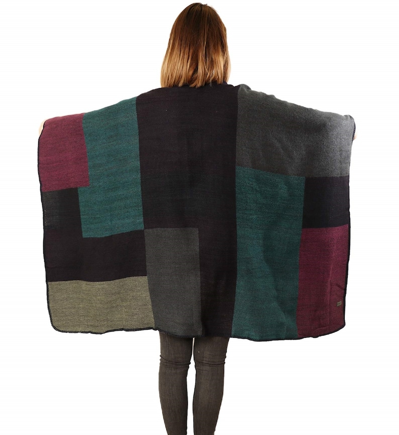 model showing the back of the poncho with all the colours, teal,black, grey, purple and grey in colourblocks