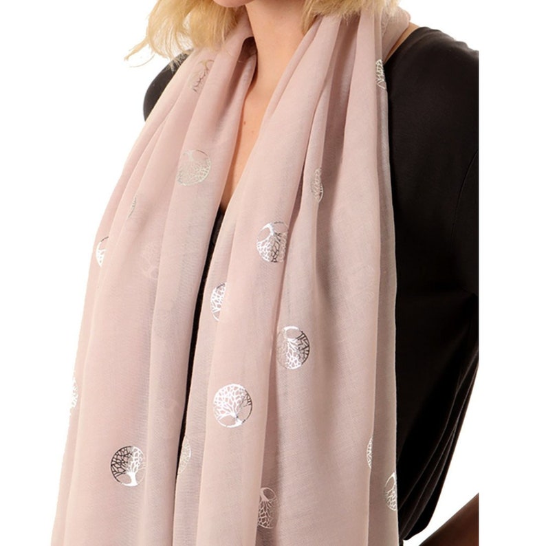 close up of a silver tree of life foil pattern on a lightweight pink scarf