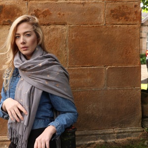 model wearing a grey winter scarf with an all over celestial print