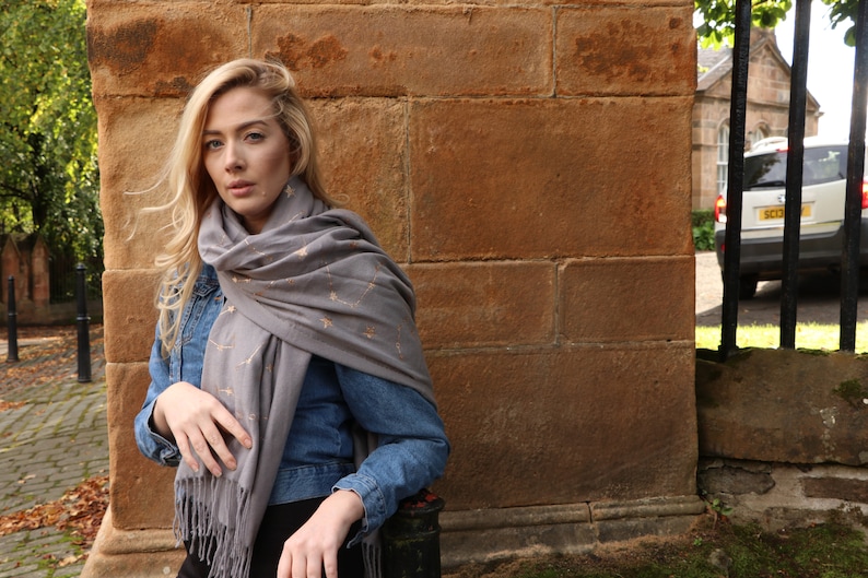 model wearing a grey winter scarf with an all over celestial print