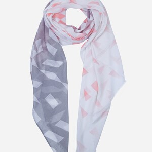 May include: A white and grey scarf with a geometric pattern. The pattern is made up of triangles and squares. The scarf is soft and lightweight.