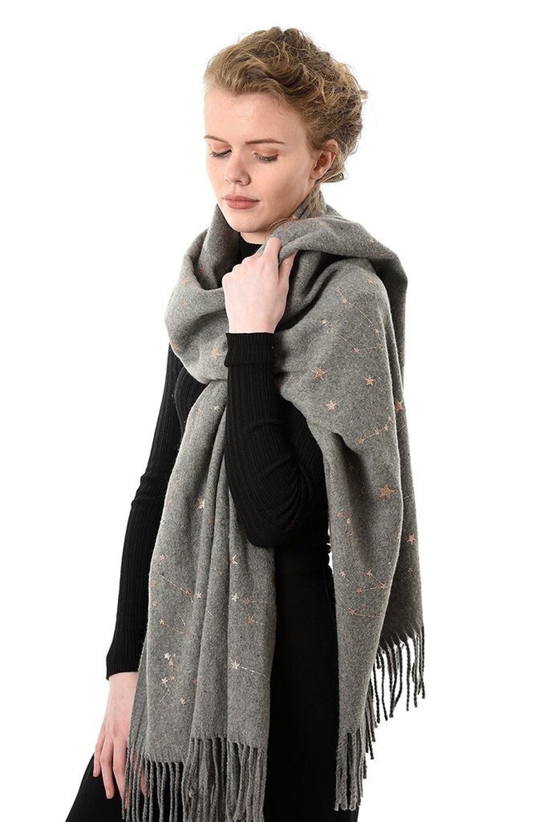 model wearing a grey blanket scarf with an all over gold constellation print