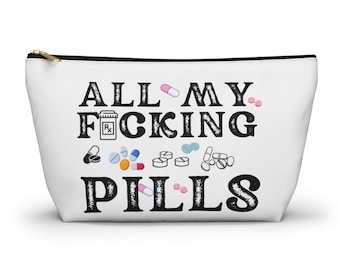 May include: White zippered pouch with the text "ALL MY F*CKING PILLS" in black. The text is surrounded by various colorful pill and capsule icons.