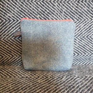 May include: A small blue and white herringbone patterned zippered pouch with a coral zipper pull.
