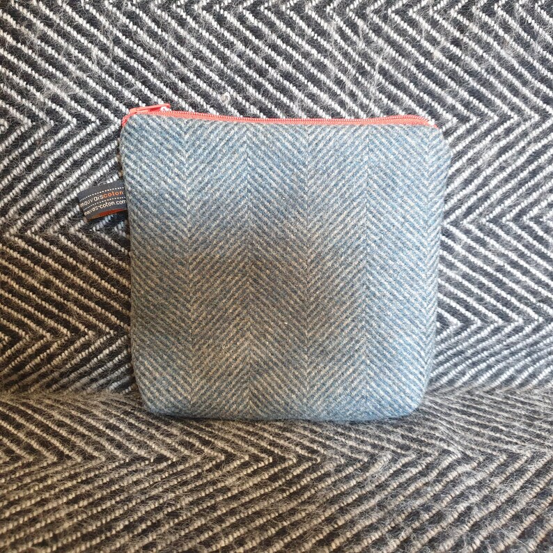 May include: A small blue and white herringbone patterned zippered pouch with a coral zipper pull.