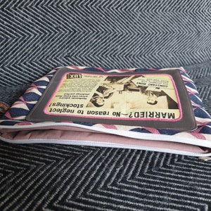 May include: A pink and blue geometric patterned zippered pouch with a vintage advertisement for Lux soap. The ad features a couple and the text "MARRIED? No reason to neglect stockings!" and "CONSTANT RUNS".