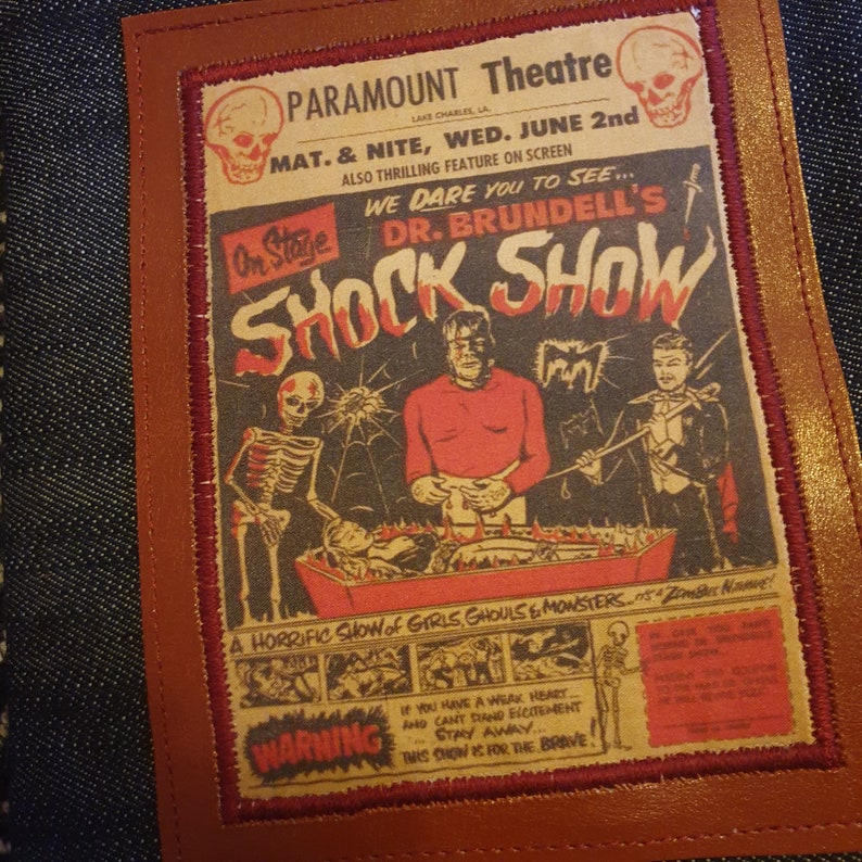 May include: A vintage-style poster for a horror show called "Dr. Brundell's Shock Show" at the Paramount Theatre. The poster features a skeleton, a monster, and a man in a tuxedo. The text on the poster reads "We dare you to see... Dr. Brundell's Shock Show. A horrific show of girls, ghouls & monsters.  Zombie Now!"