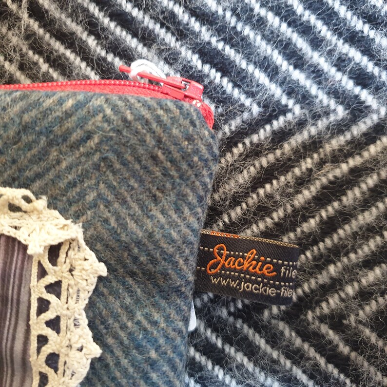 May include: A blue and green zippered pouch with a white lace trim and a black label that reads "Jackie file www.jackie-file".
