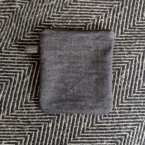 May include: A dark gray pouch with a small label that says "Made in Scotland" on the front.