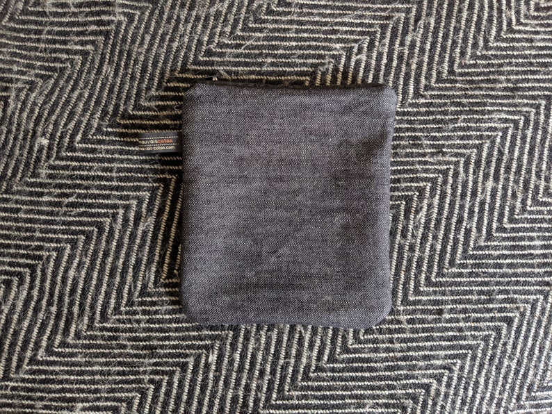 May include: A dark gray pouch with a small label that says "Made in Scotland" on the front.
