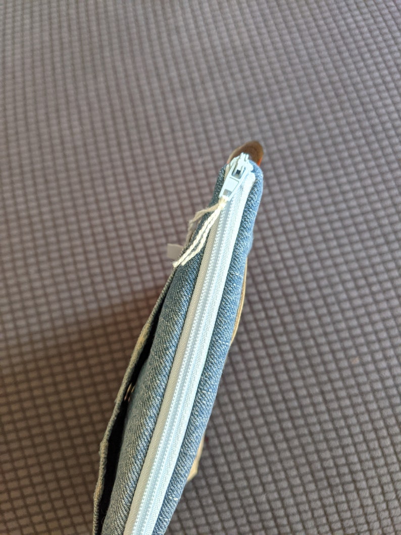 Puede incluir: Una bolsa de lona azul con cremallera blanca.