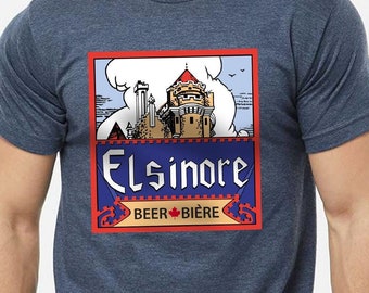 May include: A navy blue t-shirt with a vintage-style illustration of a castle and the text "Elsinore Beer Biere" in a red, white, and blue color scheme.