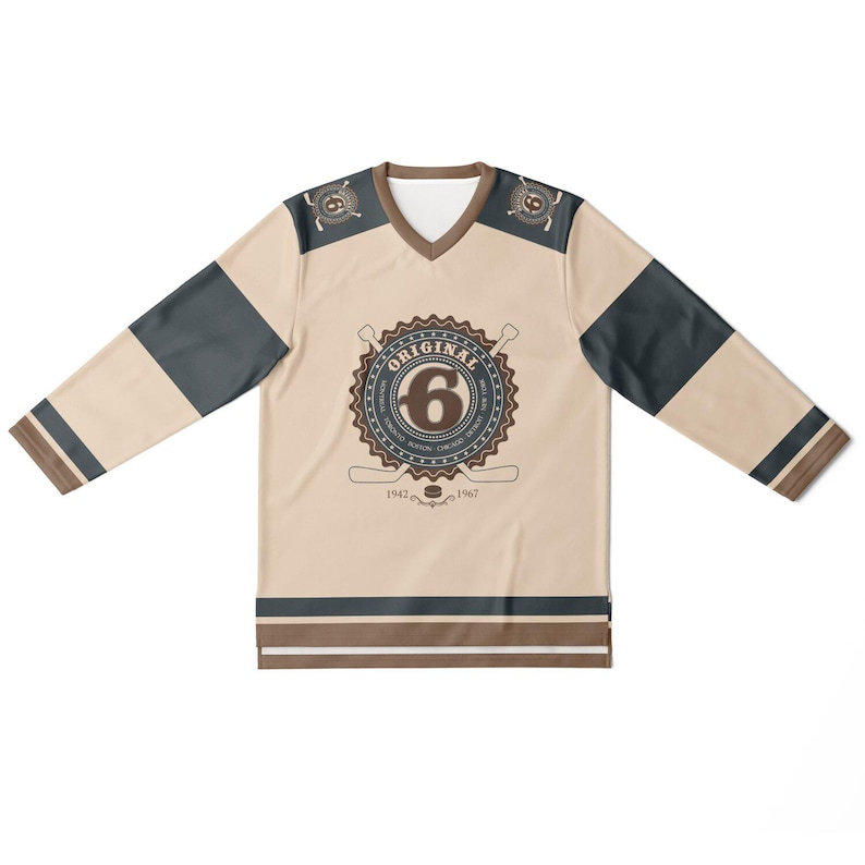 May include: A beige hockey jersey with brown and black stripes. The jersey has a large brown circle with the text "ORIGINAL" and the number "6" in the center. The text "1942" and "1967" are below the circle.