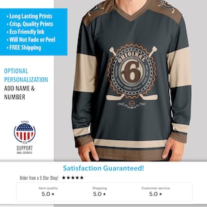 May include: A black and brown hockey jersey with a white stripe across the chest. The jersey has a large circular logo with the word "ORIGINAL" and the number "6" inside. The logo also includes the words "MONTREAL, TORONTO, BOSTON, CHICAGO, DETROIT" and the years "1942" and "1967".