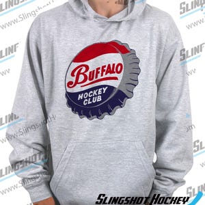 May include: A gray hooded sweatshirt with a vintage-style graphic of a bottle cap that says "Buffalo Hockey Club".