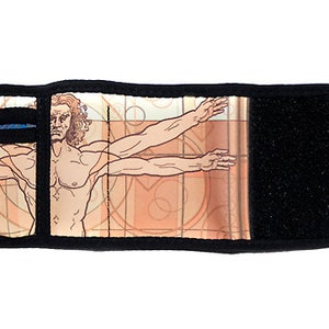 Puede incluir: Una cartera negra con cierre de velcro. La parte delantera de la cartera presenta una ilustración colorida de un hombre con los brazos extendidos.